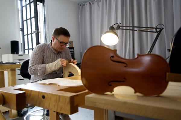 Paul Crowley diligently working on a violin. (Shenghua Sung/The Epoch Times)