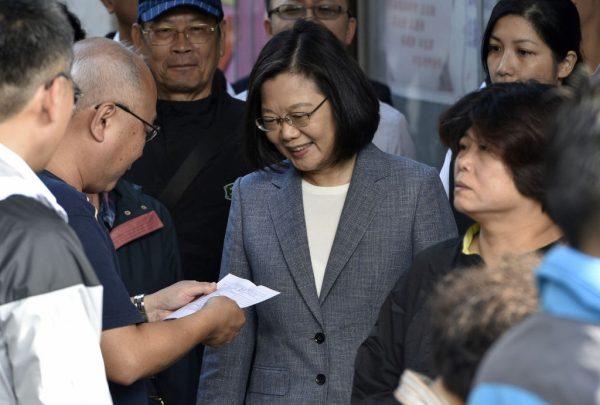 A staff member at a polling station checks documents of Taiwan's President Tsai Ing-wen (C) as she arrives at a polling station to vote during local elections in Zhongho, New Taipei City, on Nov. 24, 2018. (Sam Yeh/AFP/Getty Images)