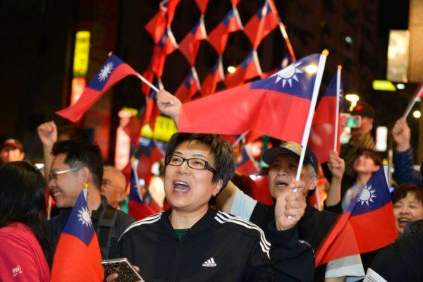 Supporters of mayoral candidate Ting Shou-chung from the Kuomintang (KMT) party wave Taiwan's national flags at Ting's campaign headquarters during local elections in Taipei, on Nov. 24, 2018. (Chris Stowers/AFP/Getty Images)