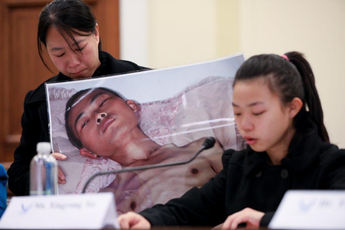 Xu Xinyang (R), a 17-year-old girl whose father (pictured) died as a result of the torture he endured in China because of his belief in Falun Gong, speaks at the "Deteriorating Human Rights and Tuidang Movement in China" forum, next to her mother Chi Lihua at Congress in Washington on Dec. 4, 2018. (Samira Bouaou/The Epoch Times)