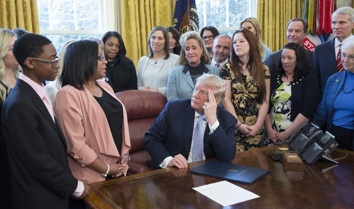 President Donald Trump listens to Yvonne Ambrose speak before signing H.R. 1865, the “Allow States and Victims to Fight Online Sex Trafficking Act of 2017” at the White House on April 11, 2018. With Trump are victims and family members of victims of online sex trafficking and members of Congress who helped pass the bill. (Chris Kleponis-Pool/Getty Images)