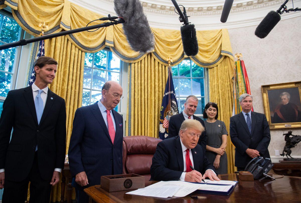 President Donald Trump signs the Save Our Seas Act, a bill which reauthorizes and amends the Marine Debris Act to promote international action to reduce marine debris, in at the White House on Oct. 11, 2018. (SAUL LOEB/AFP/Getty Images)