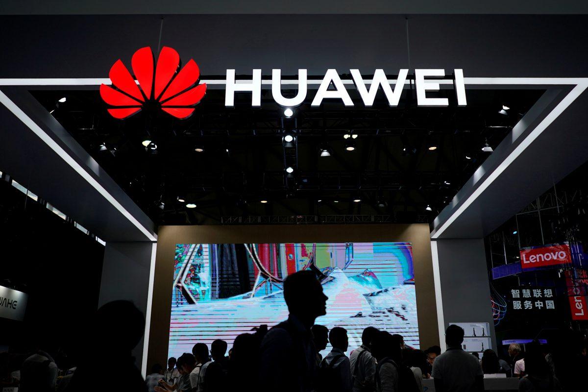 People walk past a signboard of Huawei at Consumer Electronics Show Asia 2018 in Shanghai on June 14, 2018. (Reuters/Aly Song)