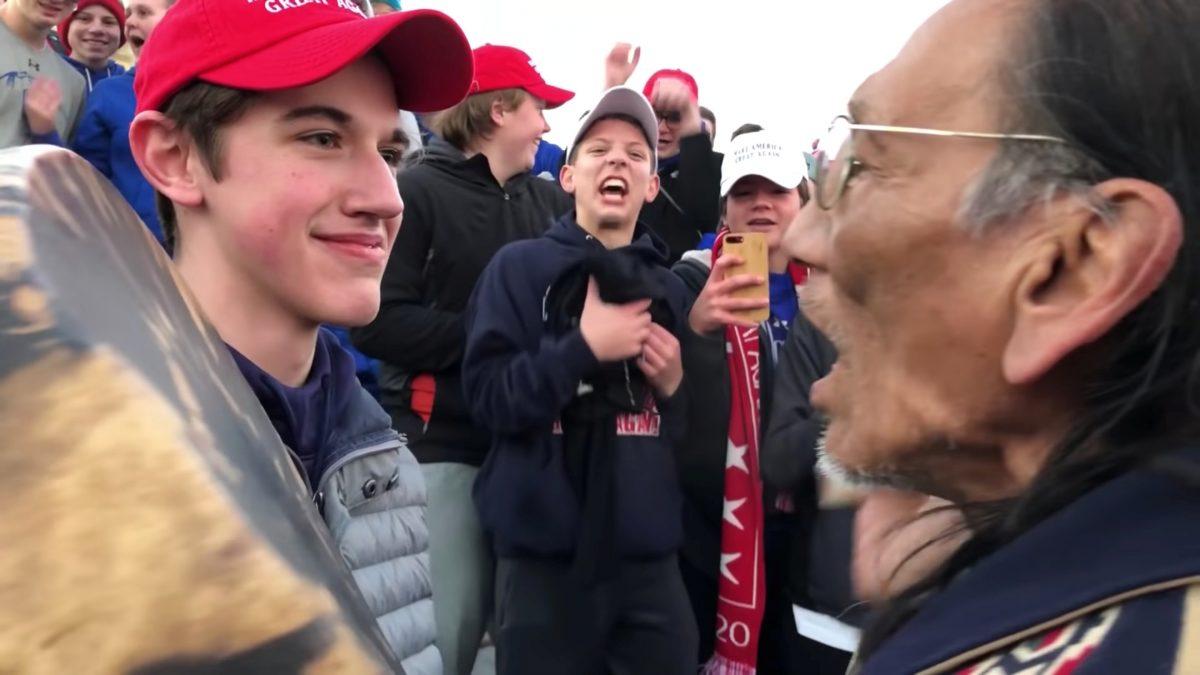 Nick Sandmann from Covington Catholic High School stands in front of Native American activist Nathan Phillips while the latter bangs a drum in his face in Washington on Jan. 18, 2019. (Kaya Taitano via Reuters)