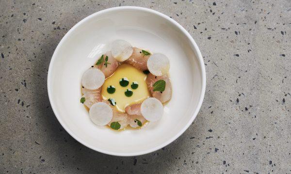 Citrus-cured fluke served with a fermented leek juice and white soy dressing. The dish is garnished with Nigella seeds, watercress, and sliced turnips. (Courtesy of Oxalis)