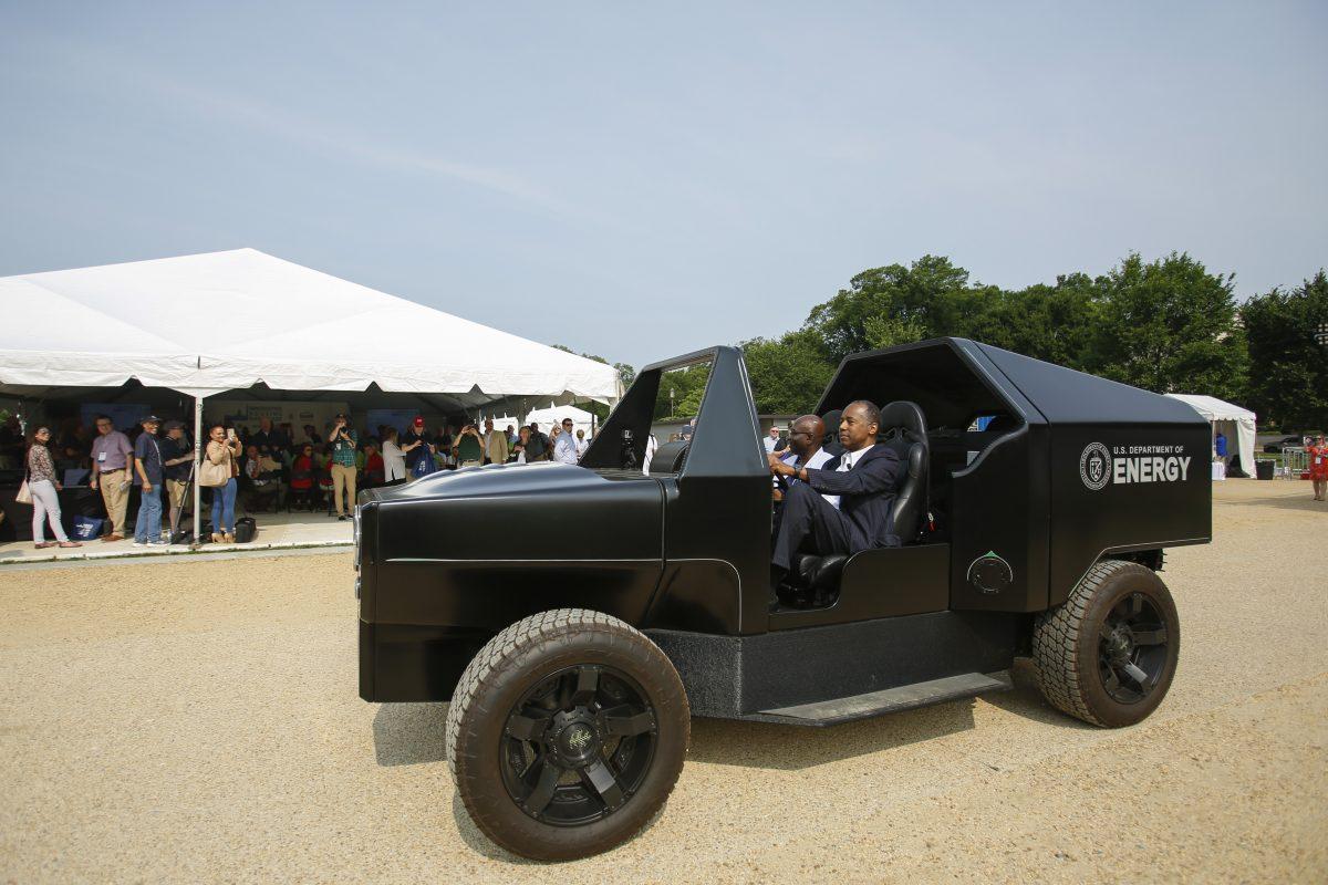 Secretary of Housing and Urban Development Ben Carson (R) drives a 3D printed car with a hybrid electric powertrain and onboard power generation from natural gas by Oak Ridge National Laboratory, at the Innovative Housing Showcase on the National Mall in Washington on June 1, 2019. (Samira Bouaou/The Epoch Times)