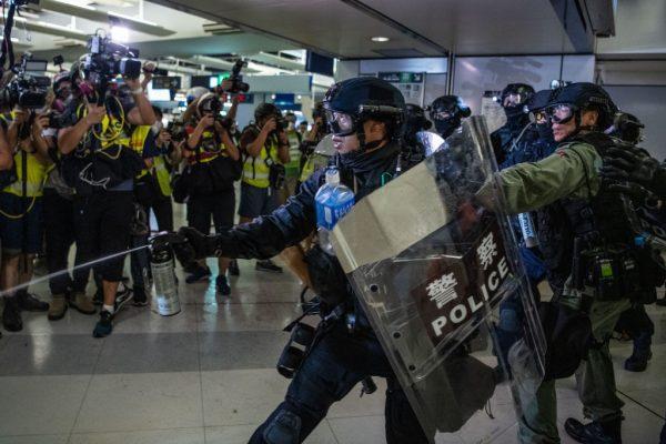 An officer uses pepper spray to disperse protesters inside a metro station in the district of Yuen Long, Hong Kong, on July 27, 2019. (Laurel Chor/Getty Images)