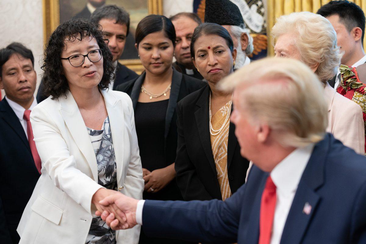 Yuhua Zhang, a Falun Gong practitioner, speaks with President Donald Trump during a meeting with survivors of religious persecution from 17 countries, in the Oval Office of the White House on July 17, 2019. (Shealah Craighead/White House)