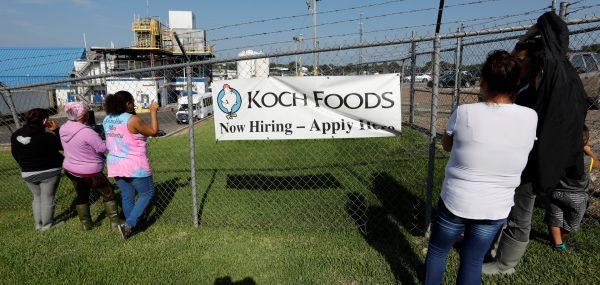 Onlookers watch as immigration officials carry out an operation at a Koch Foods meat processing plant in Morton, Miss., on Aug. 7, 2019. (Rogelio V. Solis/AP Photo)