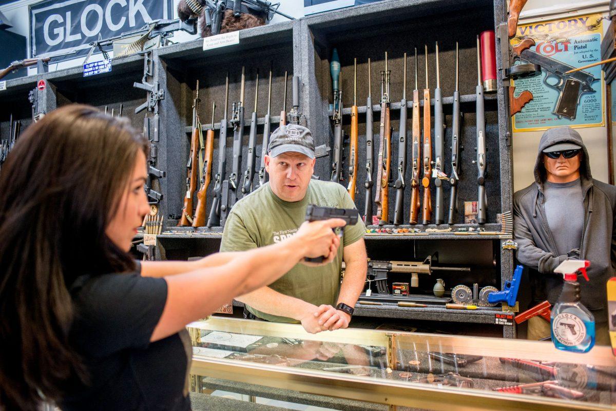 Edward Wilks, owner of Tradesmen Gun Store and Pawnshop, helps Lauren Boebert with a firearm at his store in Rifle, Colo., on April 24, 2018. (Emily Kask/AFP/Getty Images)