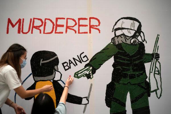 Protestors make a mural depicting a teenage demonstrator shot at close range in the chest by a police officer, in Hong Kong, Wednesday, Oct. 2, 2019. (AP Photo/Felipe Dana)