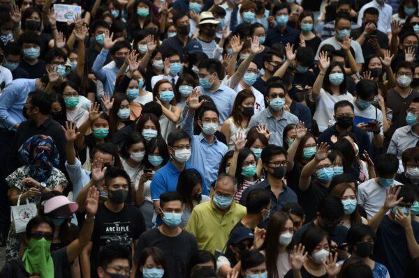 Pro-democracy demonstrators hold up their hands to symbolise their five demands during a protest against an expected government ban on protesters wearing face masks at Chater Garden in Hong Kong on Oct. 4, 2019. (Mohd Rasfan/AFP via Getty Images)