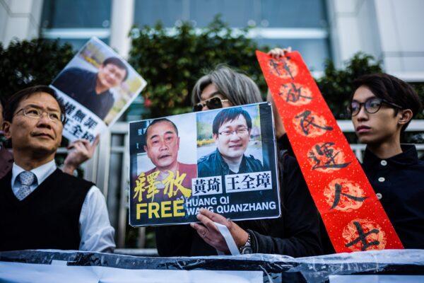 Hong Kong pro-democracy activists attend a protest in support of jailed Chinese human rights lawyer Wang Quanzhang (pictured R on placard) and China's first "cyber-dissident" Huang Qi (pictured L on placard), outside the Chinese Liaison Office in Hong Kong on Jan. 29, 2019. (Anthony Wallace/AFP via Getty Images)
