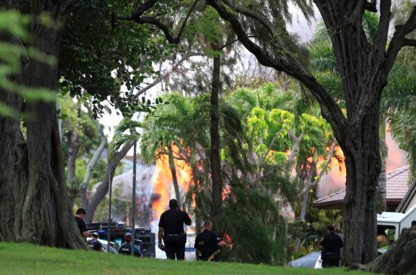 Honolulu police watch a house fire after a shooting and domestic incident at a residence on Hibiscus Road near Diamond Head in Honolulu, Hawaii, on Jan. 19, 2020. (Jamm Aquino/Honolulu Star-Advertiser).