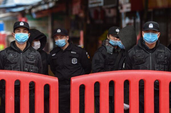 Police officers and security guards stand outside the Huanan Seafood Wholesale Market where the coronavirus was detected in Wuhan on Jan. 24, 2020. (Hector Retamal/AFP via Getty Images)