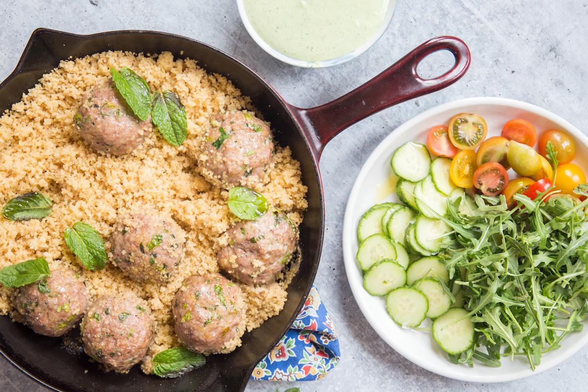 The meatballs and couscous cook in the oven in a single skillet, while you prep your whipped feta and veggies on the side. (Caroline Chambers)