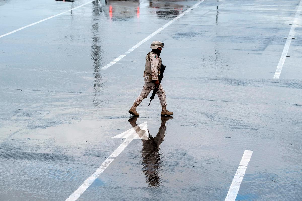 A Mexican soldier walks between lines at San Ysidro port of entry on the U.S.-Mexico border in Tijuana, Baja California state, Mexico, on March 19, 2020. (Guillermo Arias/AFP via Getty Images)