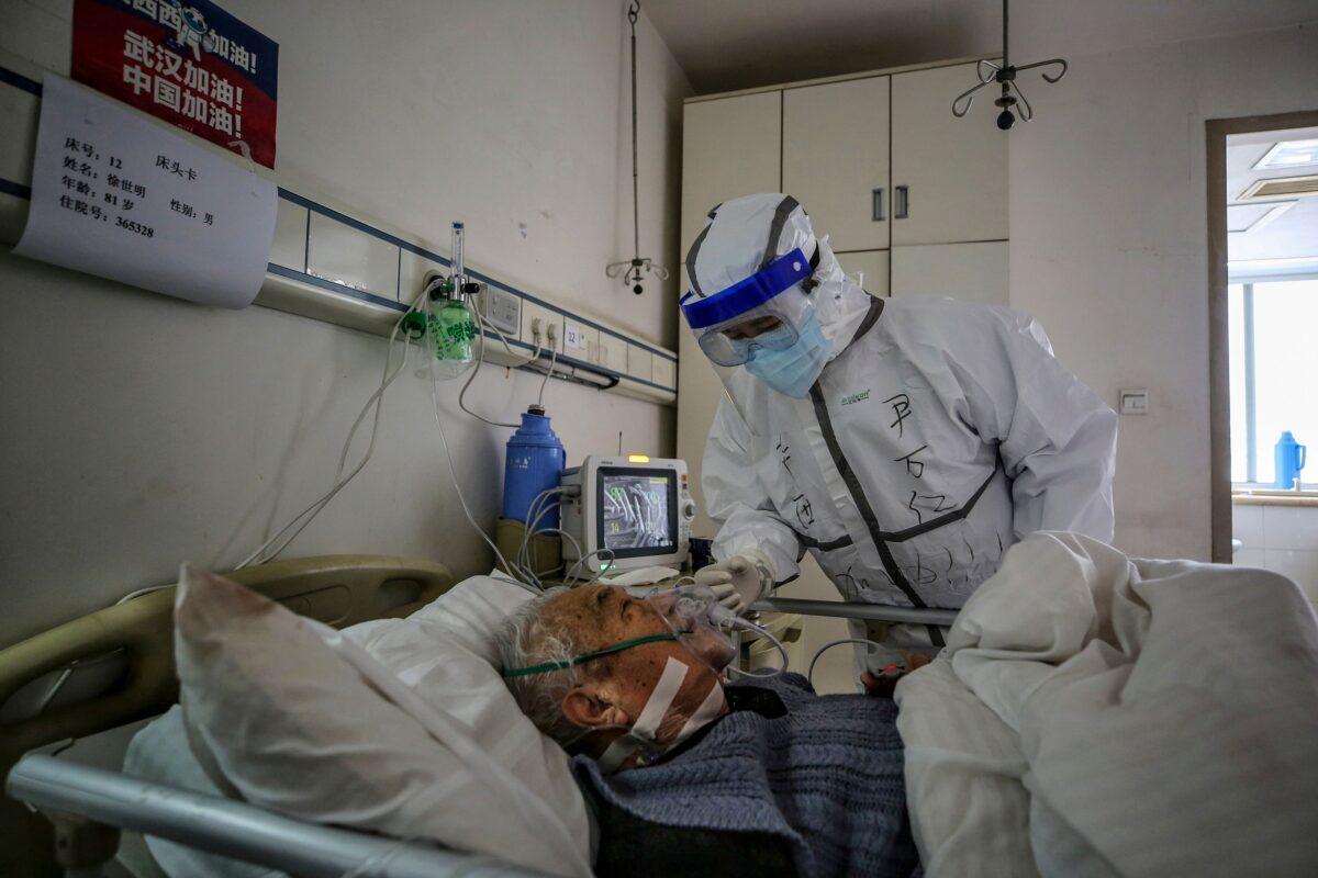 A medical staff member speaks with a patient infected by the CCP virus at Red Cross Hospital in Wuhan, Hubei province, China, on March 10, 2020. (STR/AFP via Getty Images)