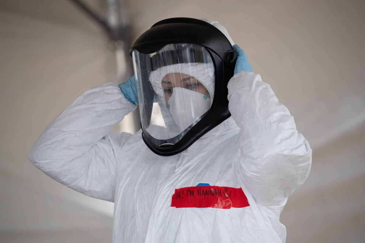 A nurse adjusts her personal protective equipment (PPE) at a COVID-19 testing station in Stamford, Conn., on March 23, 2020. (John Moore/Getty Images)