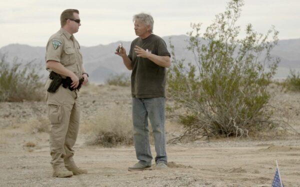 Mike Hughes (R) speaks with a Bureau of Land Management officer in Amboy, Calif. (Toby Brusseau)