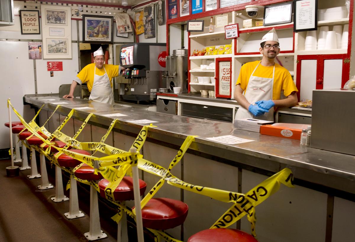 Texas Tavern employees Chris Dobe (L) and Nick Moore wait for take out orders on March 30, 2020. (Heather Rousseau/The Roanoke Times via AP)