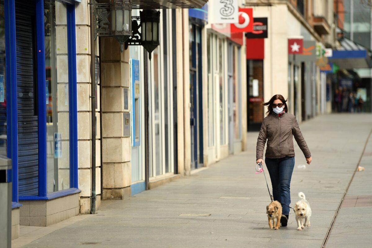 A member of the public walks her dogs down an empty high street in the city center in Exeter, England on April 2, 2020. (Dan Mullan/Getty Images)