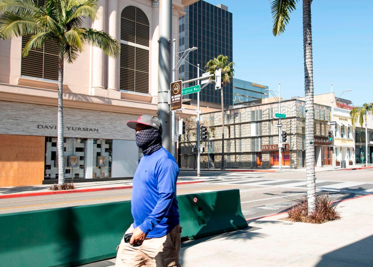 A person wearing a mask walks on Rodeo Drive in Beverly Hills, California on April 1, 2020. (Valerie Macon/AFP via Getty Images)