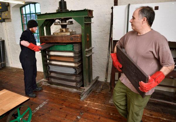 Workers at John Boyd Textiles Ltd. prepare a press full of horsehair fabric. (Rob Scott/John Boyd Textiles Ltd.)