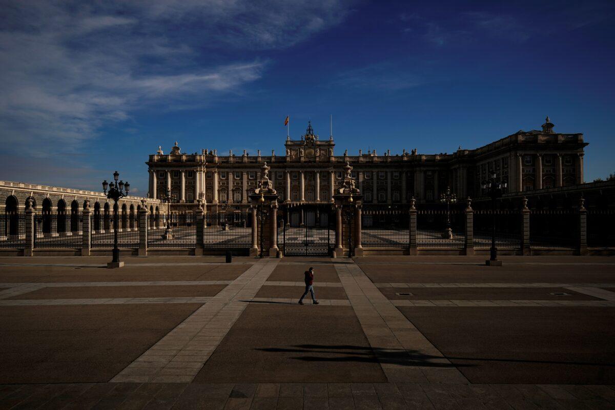A man speaks on his phone as he walks past the Royal Palace during lockdown, amid the CCP virus outbreak, in Madrid, Spain on April 5, 2020. (Juan Medina/Reuters)