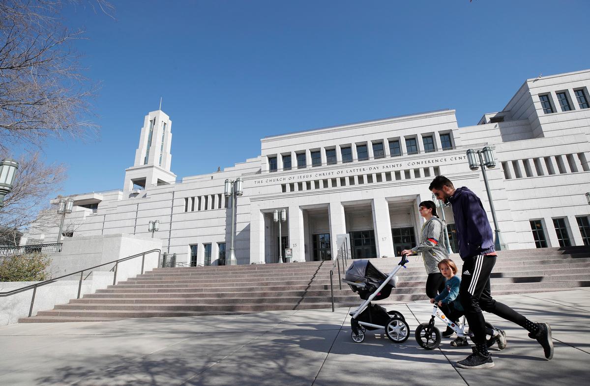 A family walks past the grounds of the Conference Center that sits empty for the 190th Annual General Conference of the Church of Jesus Christ of Latter-Day Saints in Salt Lake City, Utah, on April 4, 2020. (George Frey/Getty Images)