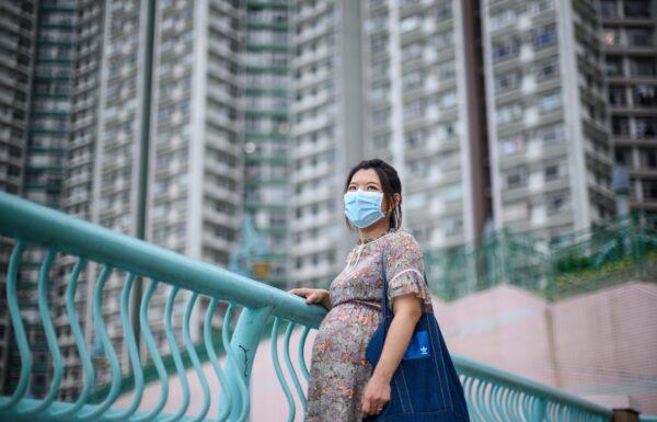Expectant mother Jamie Chui, 33, poses in front of residential buildings near where she lives in Hong Kong, on March 31, 2020. (Anthony Wallace/AFP via Getty Images)