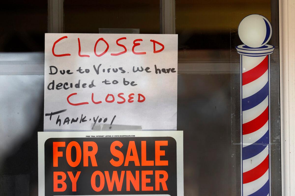 "For Sale By Owner" and "Closed Due to Virus" signs are displayed in the window of Images On Mack in Grosse Pointe Woods, Mich., on April 2, 2020. (Paul Sancya/AP Photo)
