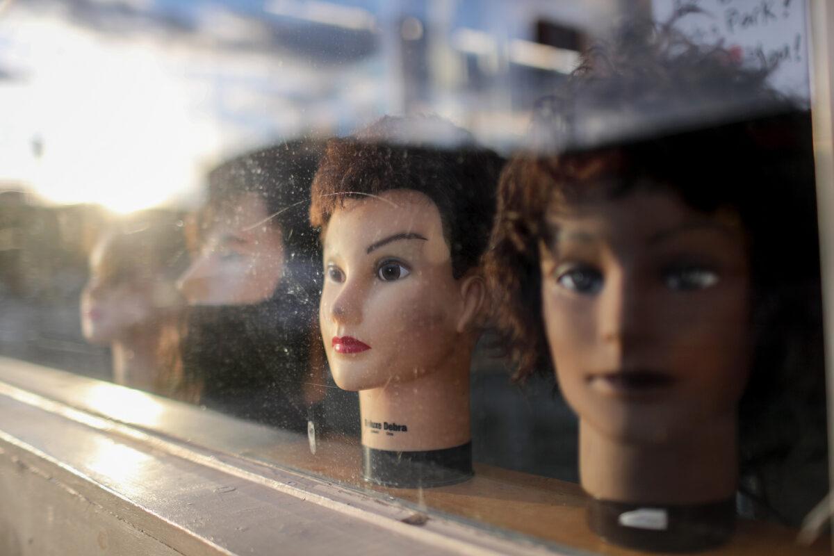 Mannequin heads remain on display inside a shuttered barber shop amidst the COVID-19 pandemic in Los Angeles, California, on April 10, 2020. (Mario Tama/Getty Images)