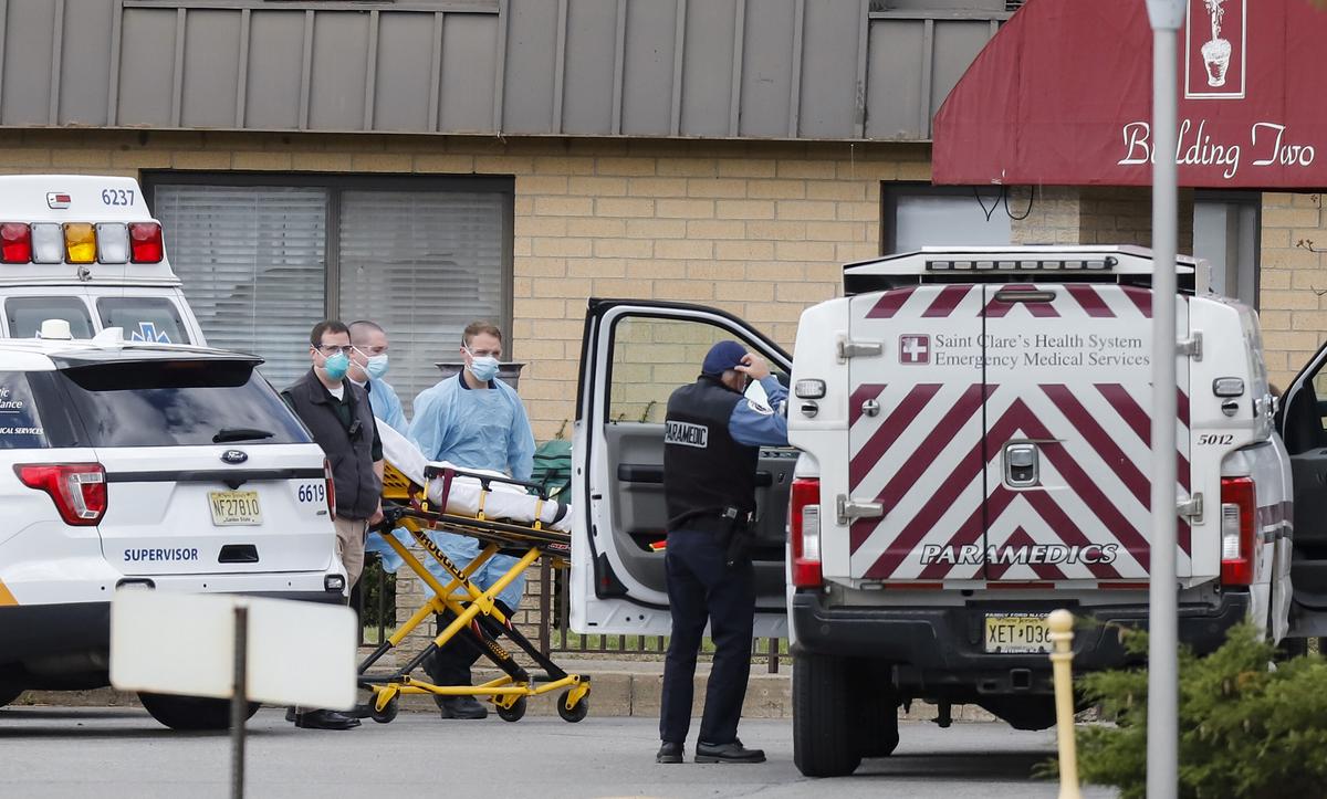Paramedics and healthcare officials are seen outside Andover Subacute and Rehab Center, during the CCP virus outbreak, in Andover, N.J., on April 16, 2020. (Stefan Jeremiah/Reuters)