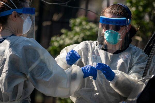 Medical professionals from Children's National Hospital administer a CCP virus test at a drive-thru testing site for children age 22 and under at Trinity University in Washington on April 2, 2020. (Drew Angerer/Getty Images)