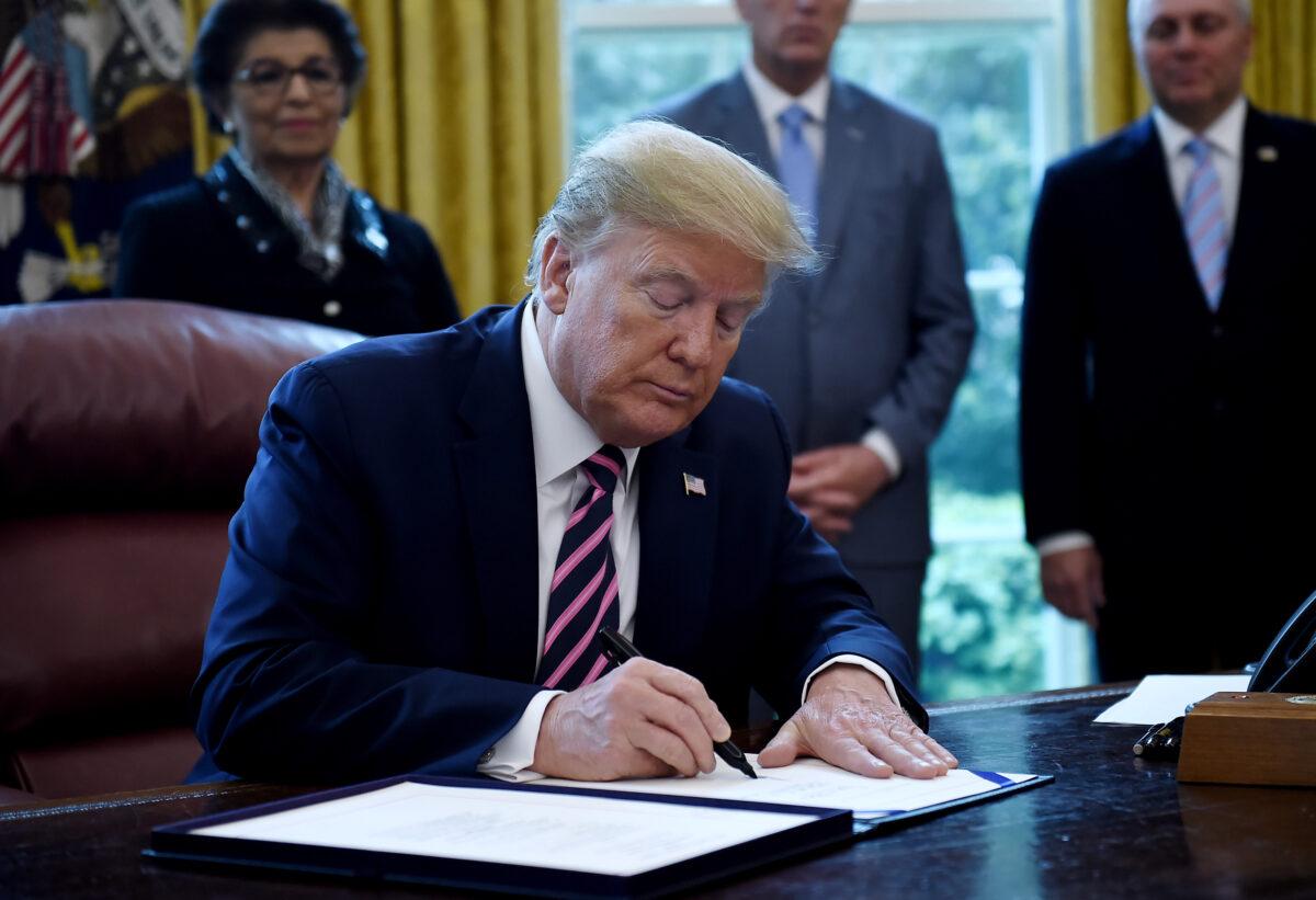 President Donald Trump signs the Paycheck Protection Program and Health Care Enhancement Act in the Oval Office of the White House in Washington on April 24, 2020. (Olivier Douliery/AFP via Getty Images)