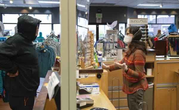 Marsha Howard, right, helps Jason Gjertsen at the Work & Rugged Gear Store in Sitka, Alaska on April 24, 2020. (James Poulson/The Daily Sitka Sentinel via AP)