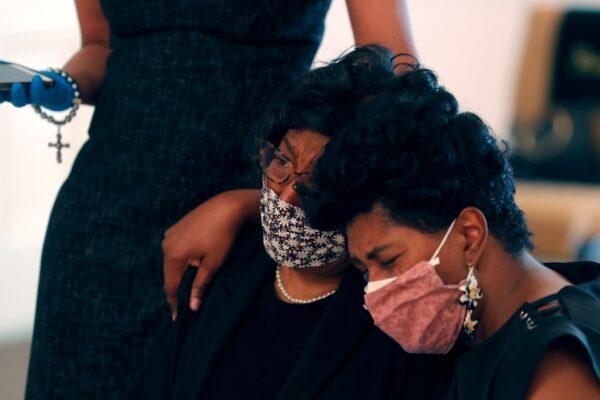 Lillian P. Hammond (C) is comforted by her daughter Nicole Hammond Crowden (R) and sister-in-law Lori Adams (L) at the funeral for her husband Larry Hammond, who died from the CCP virus, in New Orleans, on April 22, 2020. (Gerald Herbert/AP Photo)