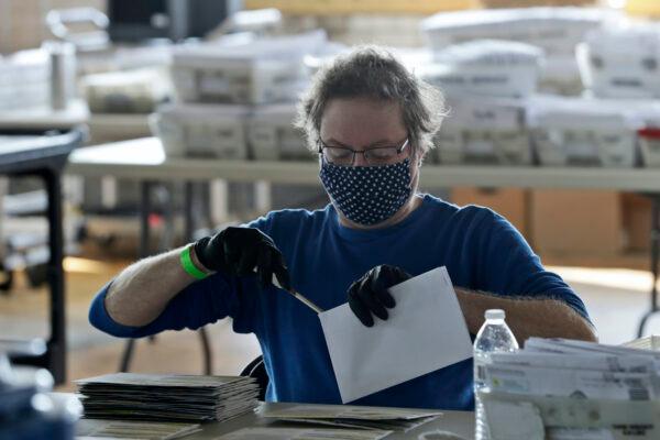 Board of election worker John Carlino opens a ballot at the warehouse where the ballots are counted for the Cuyahoga County Board of Elections, in Cleveland, Ohio, on April 28, 2020. (Tony Dejak/AP photo)