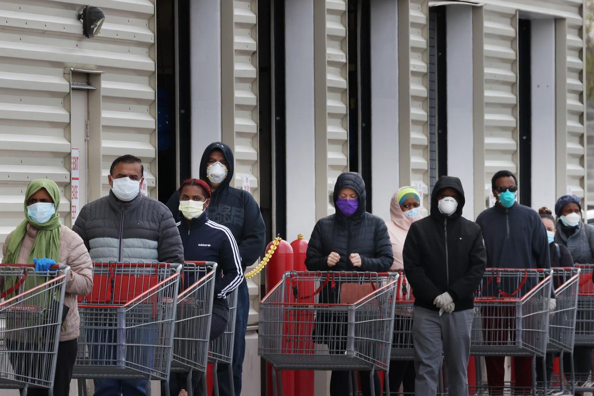 Customers wear face masks to prevent the spread of the novel coronavirus as they line up to enter a Costco in Wheaton, Maryland, on April 16, 2020. (Chip Somodevilla/Getty Images)