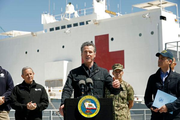 California Governor Gavin Newsom, center, speaks next to Los Angeles Mayor Eric Garcetti, right, in front of the hospital ship USNS Mercy that arrived into the Port of Los Angeles on March 27, 2020. (Carolyn Cole/Los Angeles Times via AP, Pool, File)