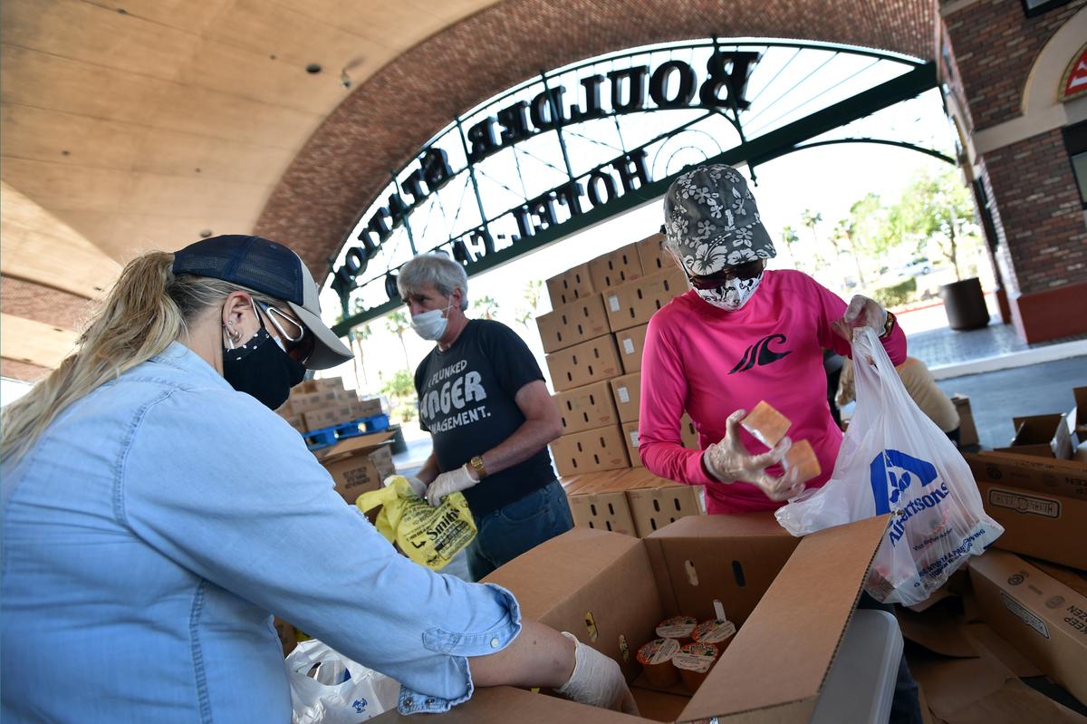Volunteers prepare groceries to be given out at a drive-thru Three Square Food Bank emergency food distribution site at Boulder Station Hotel & Casino in response to an increase in demand amid the COVID-19 pandemic in Las Vegas, Nevada, on April 29, 2020. (David Becker/AFP via Getty Images)