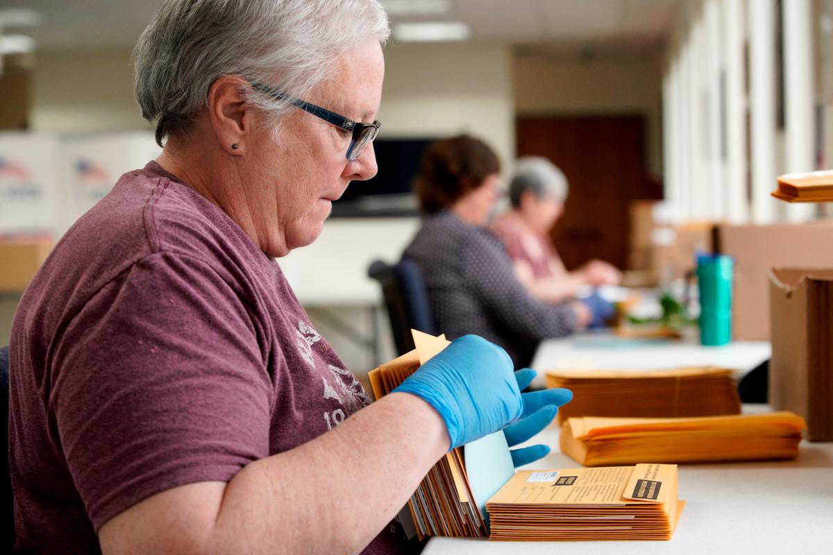 Pam Fleming and fellow workers stuff ballots and instructions into mail-in envelopes at the Lancaster County Election Committee offices in Lincoln, Neb., on April 14, 2020. (Nati Harnik/AP Photo)