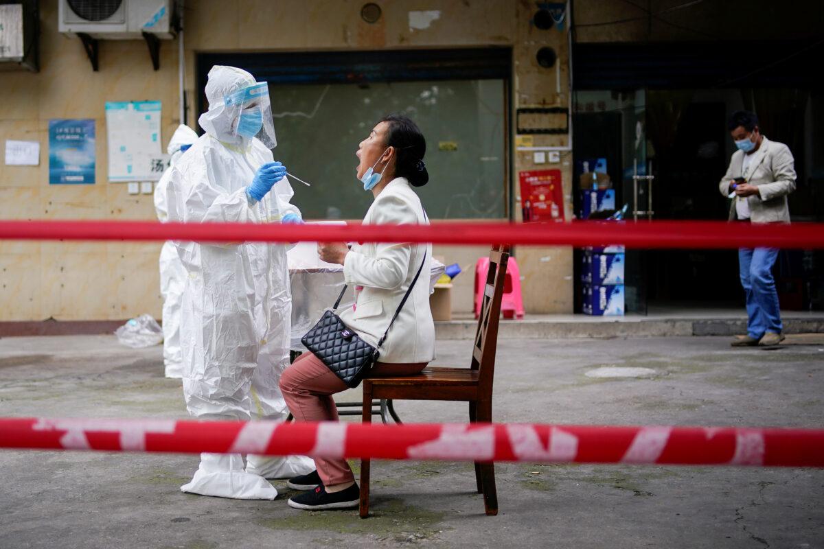 A medical worker in protective suit conducts nucleic acid testings for residents at a residential compound in Wuhan, the Chinese city hit hardest by the coronavirus disease (COVID-19) outbreak, Hubei province, China, on May 15, 2020. (Aly Song/Reuters)