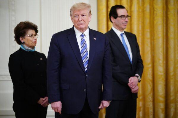 President Donald Trump is flanked by SBA Administrator Jovita Carranza (L) and Treasury Secretary Steven Mnuchin, at a briefing at the White House in Washington, on April 28, 2020. (Mandel Ngan/AFP/Getty Images)