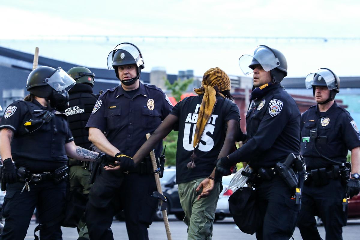 A protester is detained by State Police after staying out beyond the governor’s 8 p.m. curfew during the sixth night of protests and violence following the death of George Floyd, in Minneapolis, Minn., on May 31, 2020. (Charlotte Cuthbertson/The Epoch Times)
