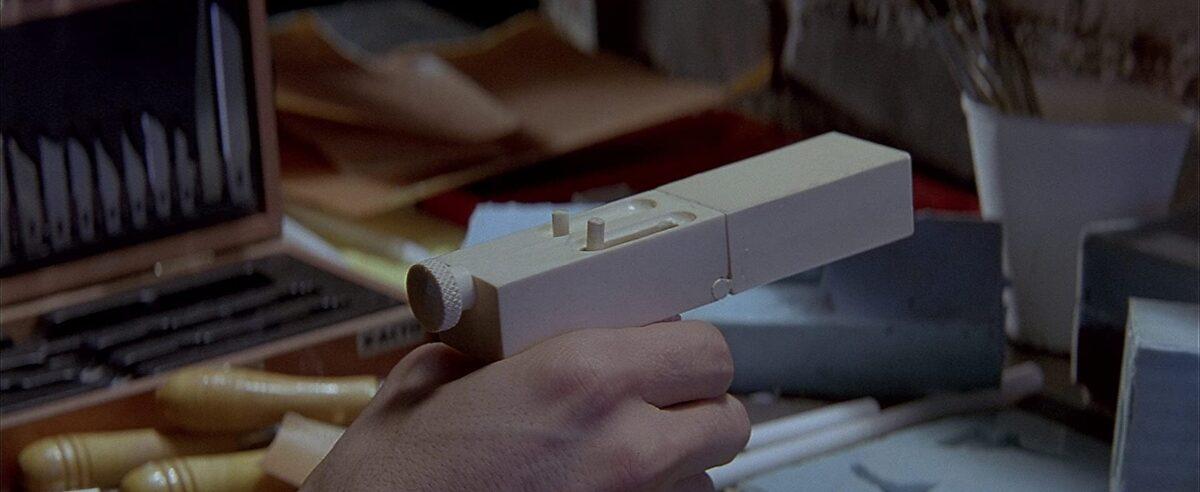 Former CIA assassin Mitch Leary tests his undetectable plastic gun in "In the Line of Fire." (Columbia Pictures)