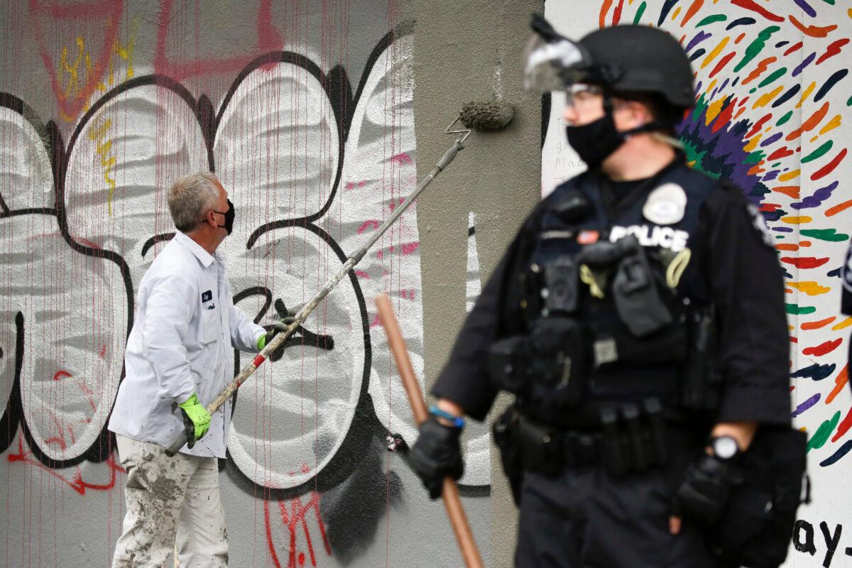A worker paints over graffiti after police cleared the Capitol Hill Organized Protest (CHOP) area in Seattle on July 1, 2020. (Jason Redmond/AFP via Getty Images)