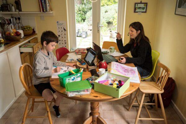 Six-year-old Leo completes a homeschool activity suggested by the online learning website of his infant school, as his mother Moira, an employee of a regional council, works from home in the village of Marsden, near Huddersfield, northern England on May 15, 2020, during the novel coronavirus COVID-19 pandemic. (Photo by OLI SCARFF/AFP via Getty Images)