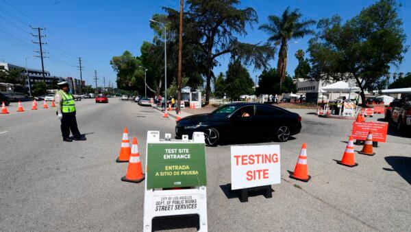 An officer directs traffic in front of a COVID-19 drive-through test site in Los Angeles, Calif., on July 17, 2020. (Frederic J. Brown /AFP via Getty Images)